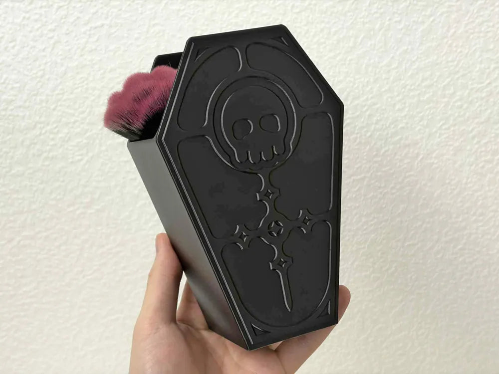High-detail 3D printed skull relief sculpture on a decorative coffin lid for spooky desk storage.