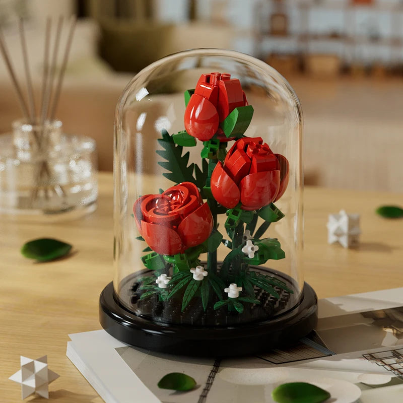Red roses eternal flower building block model in a glass dome on a wooden surface