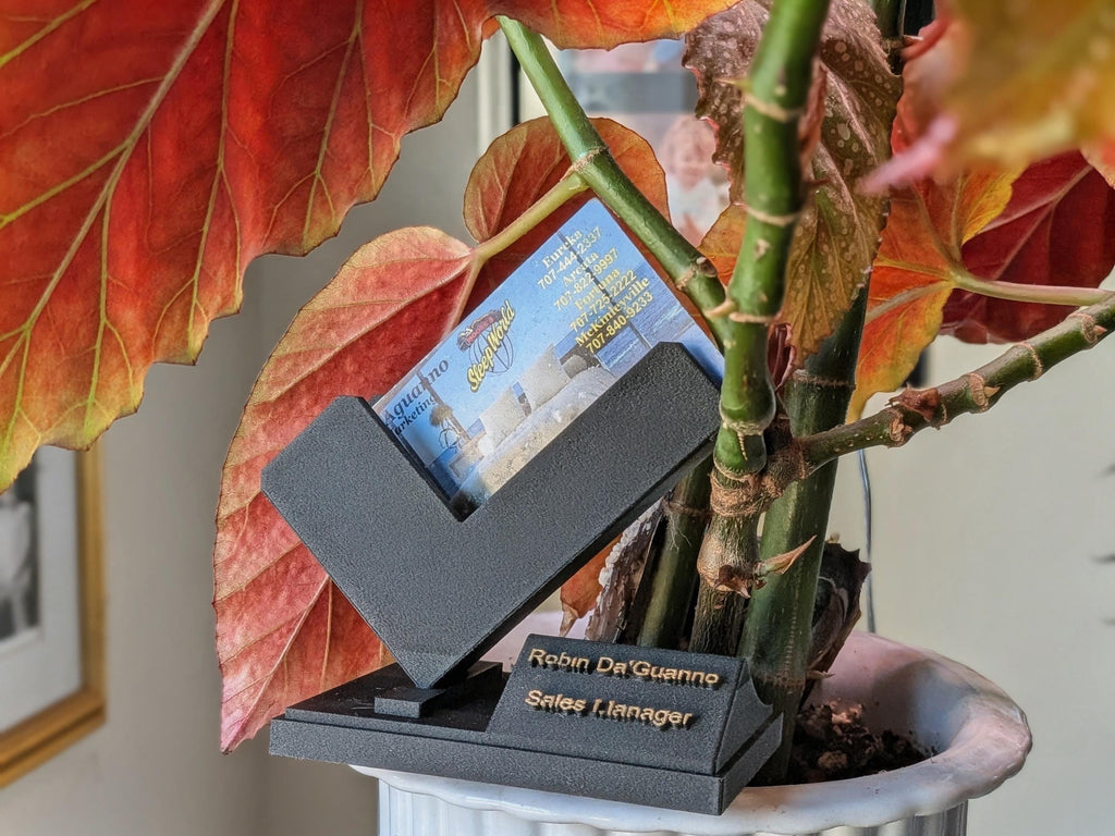 Architectural business card stand with 45-degree ergonomic tilt and precision-engineered industrial polymer finish.